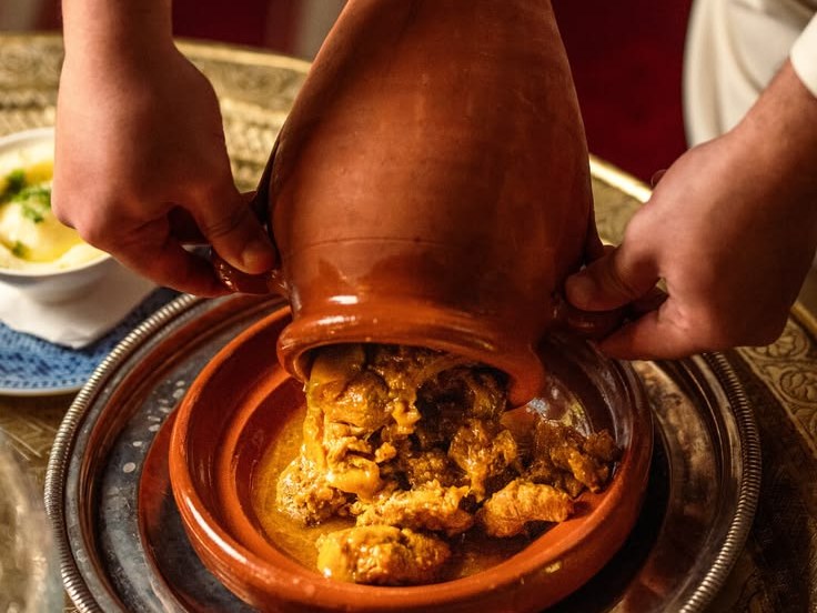 Moroccan tangia being served from its traditional clay urn