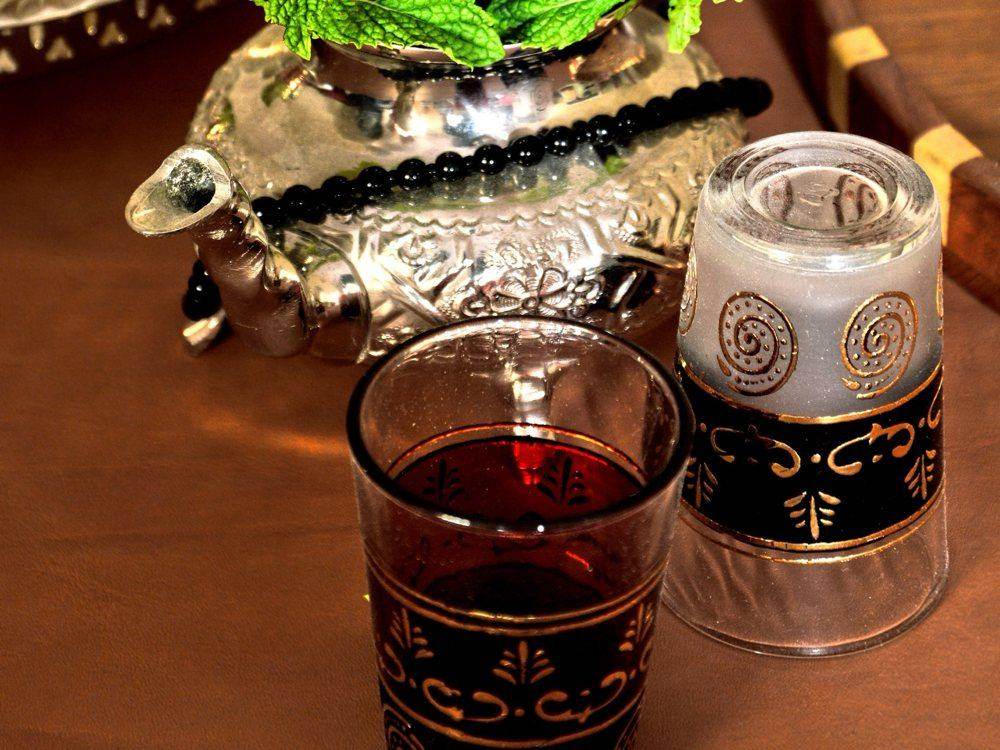 Moroccan mint tea: a silver teapot filled with fresh mint and a decorated tea glass