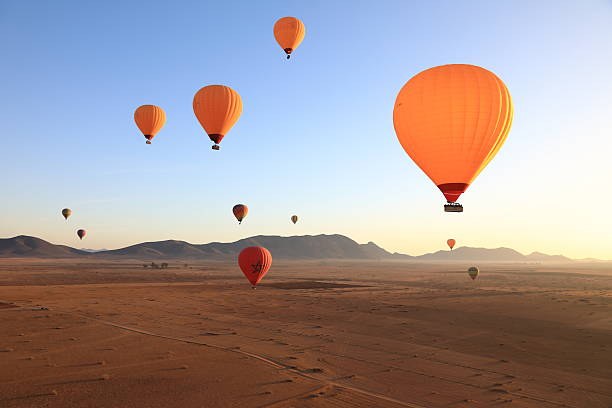 Hot air balloons lifting off at dawn