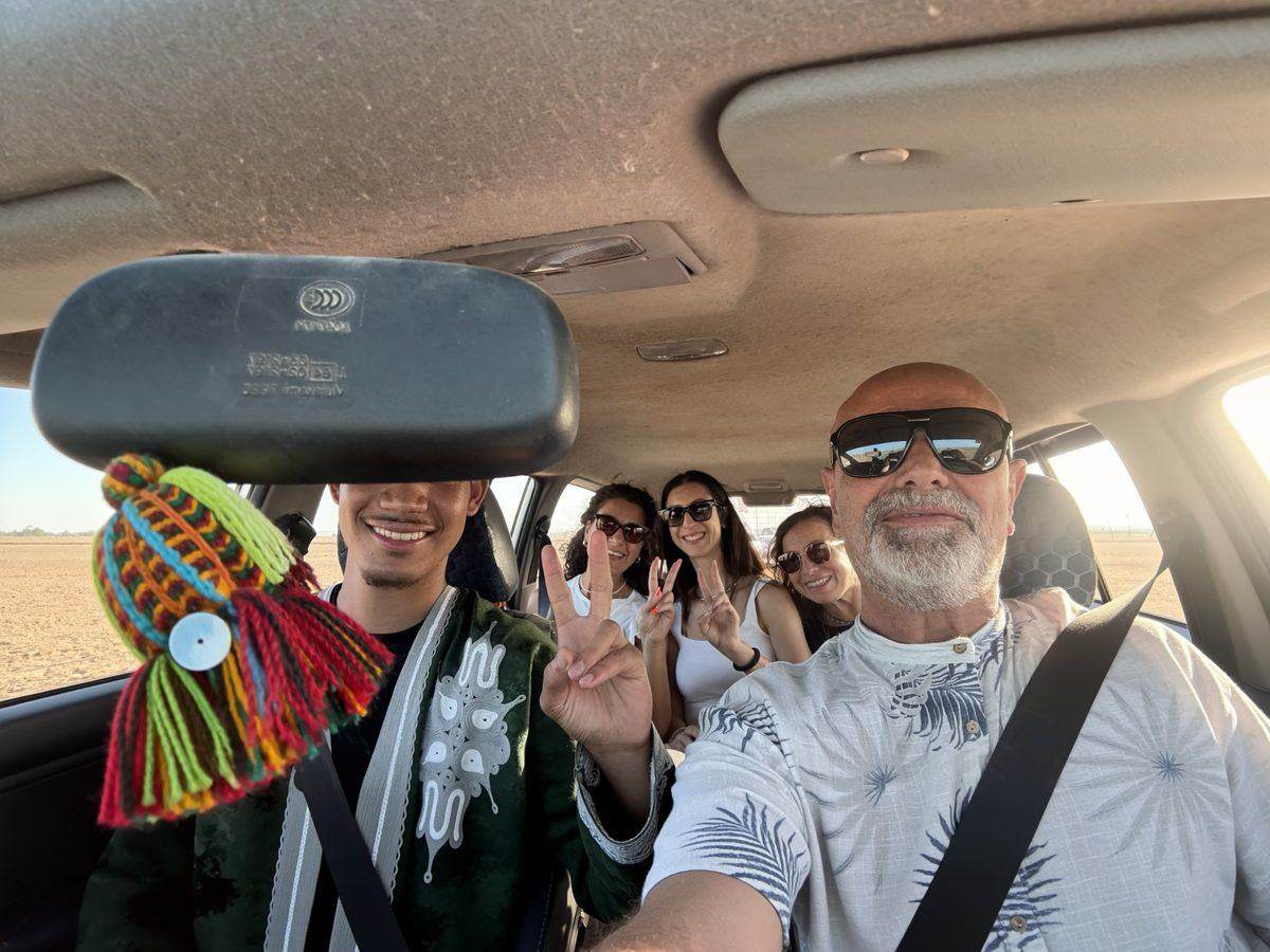 Smiling travellers on the road with their Royal Morocco Travel driver